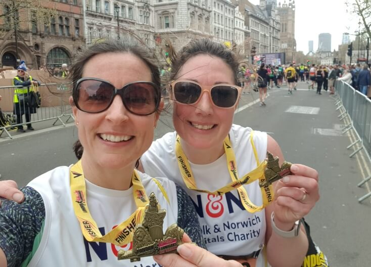 Two fundraisers showing their running medals